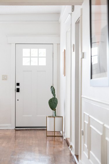 Hallway Furniture Ideas with A hallway with white walls, wood floors and a cactus plant