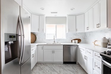 Minimalist kitchen with white cabinets, countertops and gray accents