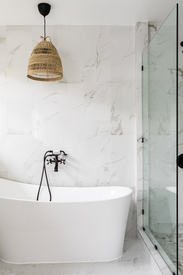 white modern bathroom with freestanding tub and black tub and shower fixtures