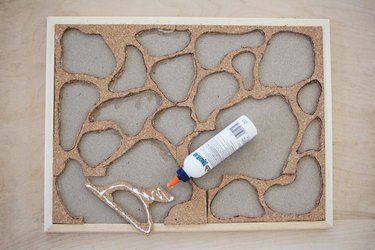 gluing pieces of cork to a bulletin board frame