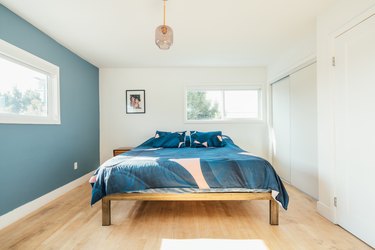 Bedroom with teal walls, blue bedding.