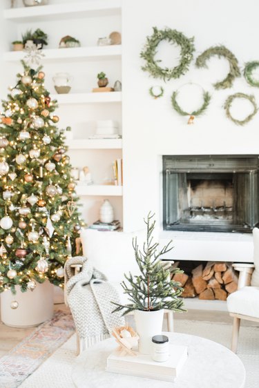 white and gold Christmas colors in living room fireplace with Christmas tree and boho decor