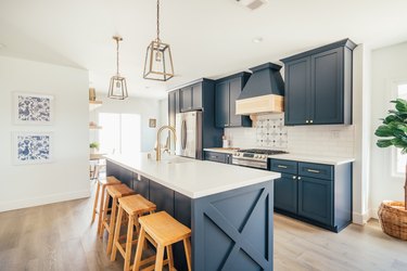 A blue modern farmhouse kitchen with an island sink