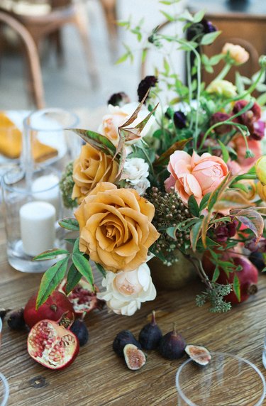 a floral centerpiece with yellow, pink, and white flowers