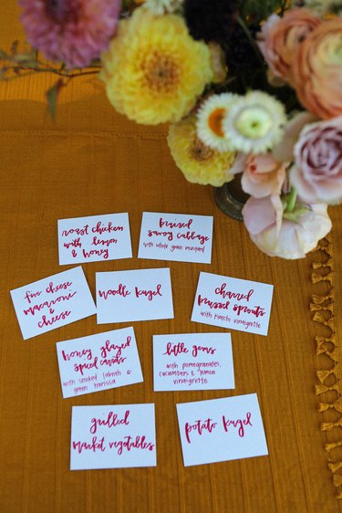 hand-written cards on a table describe each dish