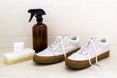 Countertop with sneakers, spray bottle, and sponge