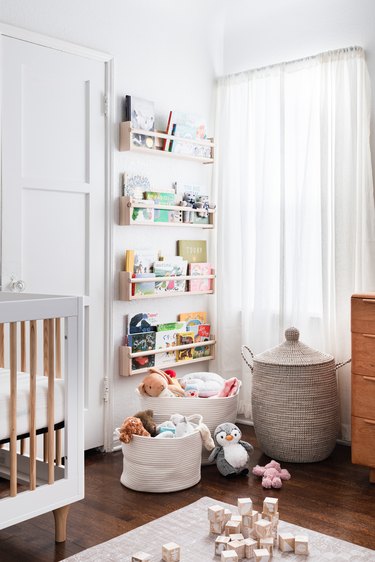 book storage in white nursery with wall mounted bookshelf