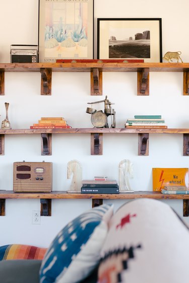 old books, vintage toys, and small pieces of art on rustic wooden shelves