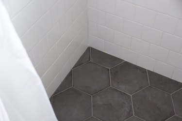 grey hexagonal and white subway tile shower floor and walls