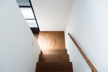 the stairwell shows clean white walls and warm wood floors