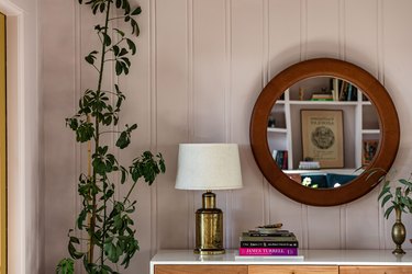 lampshade on brass lamp on credenza next to mirror