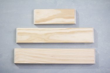 Three plywood panels against grey background
