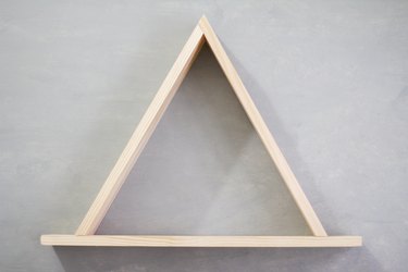 Wooden triangle frame against grey background