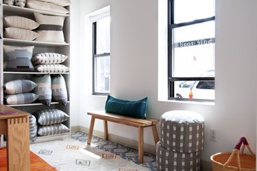 textile store with shelves and a bench near two windows