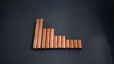 pieces of copper pipe of various lengths laid out on a table