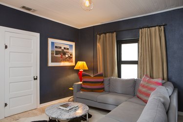 A living room with gray-pink-beige accents and blue walls