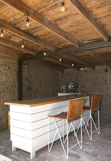 Contemporary Bar with wood counter, string lights, wood beam ceiling and industrial fan