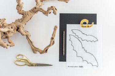 a bare branch, scissors, black construction paper, tape, a pencil, and bat cut-out templates