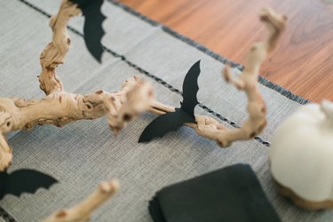 a centerpiece made from a found branch and paper bat cut-outs in the middle of a table