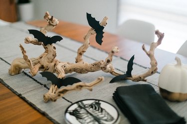 a centerpiece made from a found branch and paper bat cut-outs in the middle of a table