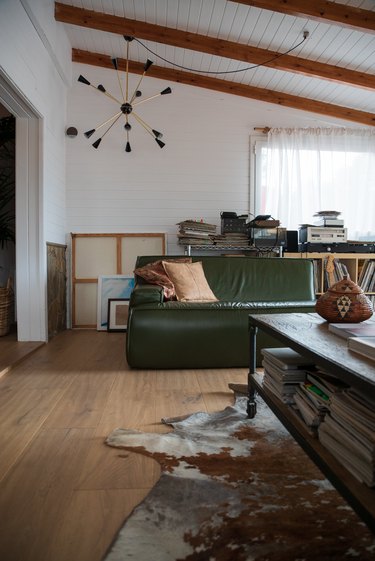 Living room with wood floors, wood beam ceiling, hide rug and eclectic furnishings