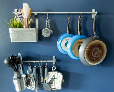 Hanging pots and pans against royal blue wall