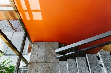 Concrete indoor stairs along burnt orange wall