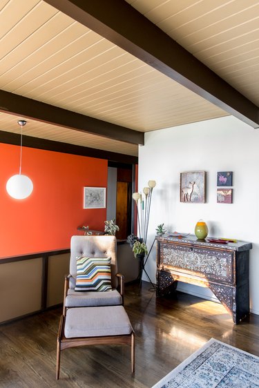 Midcentury room with beamed ceiling and burnt orange wall