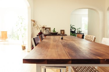 wood dining table close up with woven dining chairs