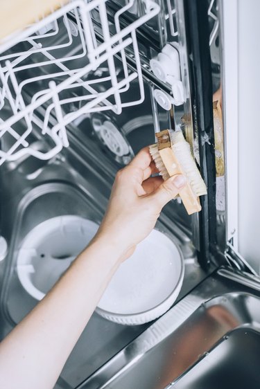 scrubbing the inside of a dishwasher