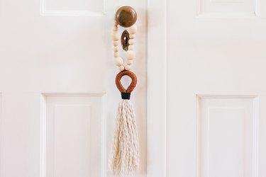 DIY door tassel hanging from white door against white wall