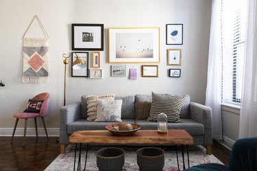 Living room with an art wall, wood coffee table and gray-pink accents