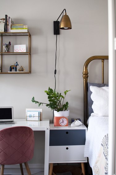 A bedroom with brass accents and a white office desk
