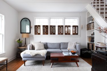 White living room with brown shutters and dark farmhouse furniture