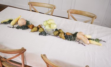 large fruits and vegetables such as melons, squash, and pears form an edible  table runner