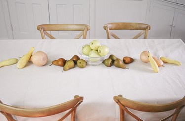 large fruits and vegetables such as squash and pears form the base of an edible table runner