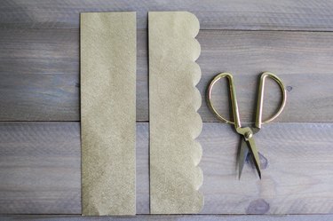 Sheets of gold paper next to gold scissors