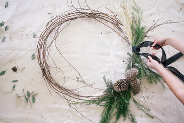 Grapevine wreath with dried plants, acorns and black ribbon
