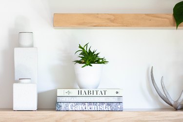 white decor on open shelving with potted plant