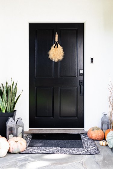 black exterior door with autumn decor