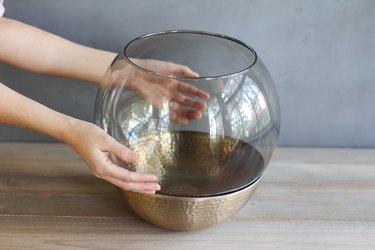 placing a glass lamp globe inside a copper bowl