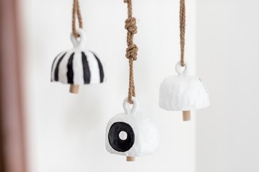 Bells made of clay, black and white paint, and rope
