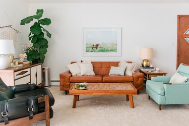 Living room with leather and wood furniture and white carpeting
