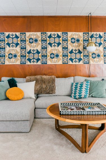 Living room with wood wall and blue, yellow, gray decor and furnishings