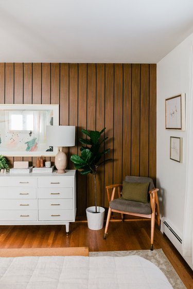 White/wood walled living room with white sideboard vintage accent chair and beige rug