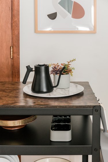 Farmhouse kitchen island with dishware and small plant on wood top