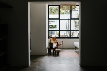 A room with a big window and a tile floor.