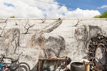 A mural of animals with a worktable, bicycle and a sculpture