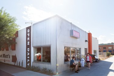 A restaurant with corrugated metal and orange-brown signage