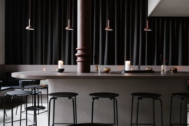 Minimalist bar with brown and black dining furniture and pendant lights